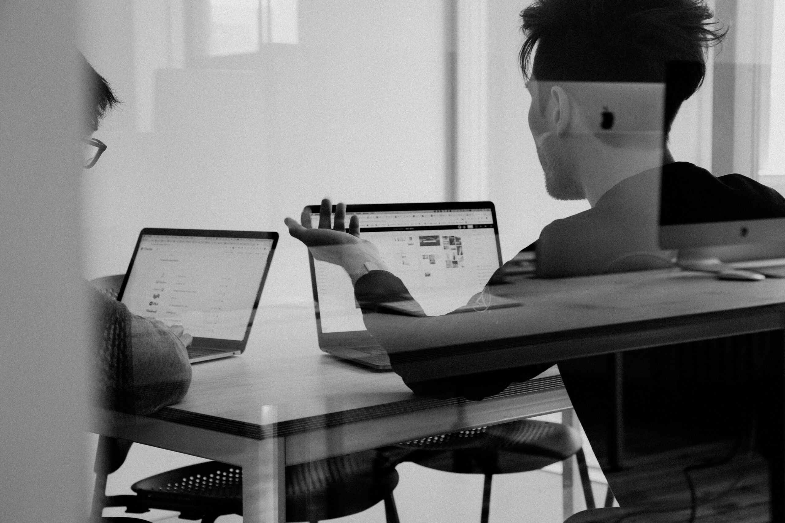 Two men discussing information on a computer