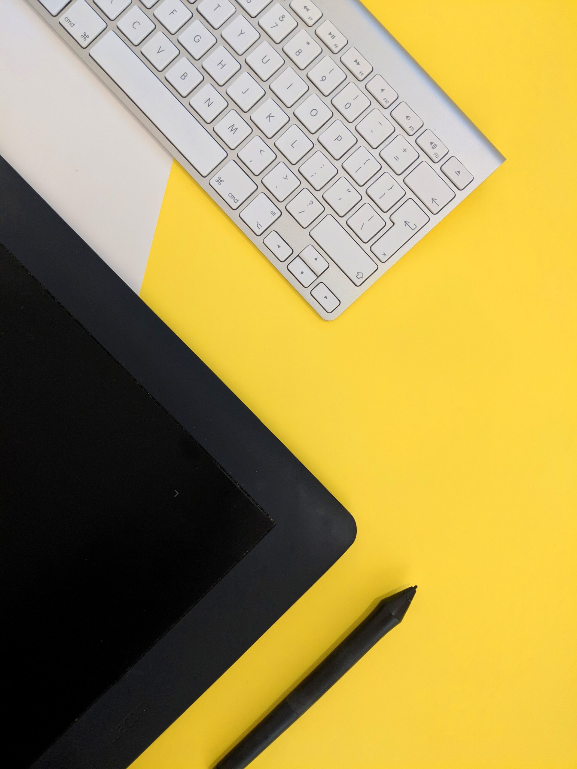 A white keyboard on a yellow table